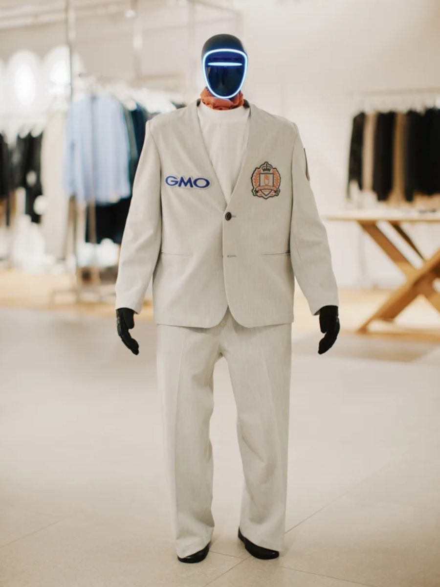 ジャケット、パンツ、Tシャツ、スカーフを着けた人型ロボット