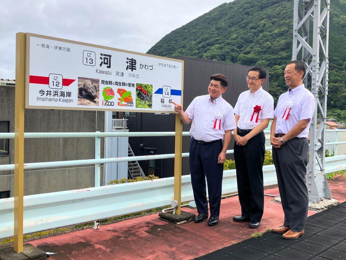副駅名を指さすレップジャパン白輪社長（左）と、伊豆急行・清水社長（中央）、大川河津町長（右）