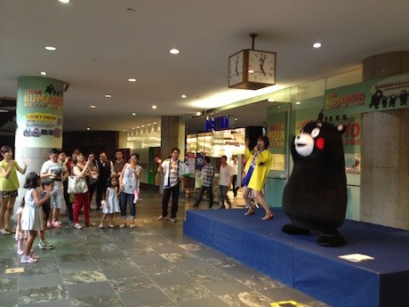 店頭のステージでショーを披露するくまモン。一緒に踊る子どもたちの姿も
