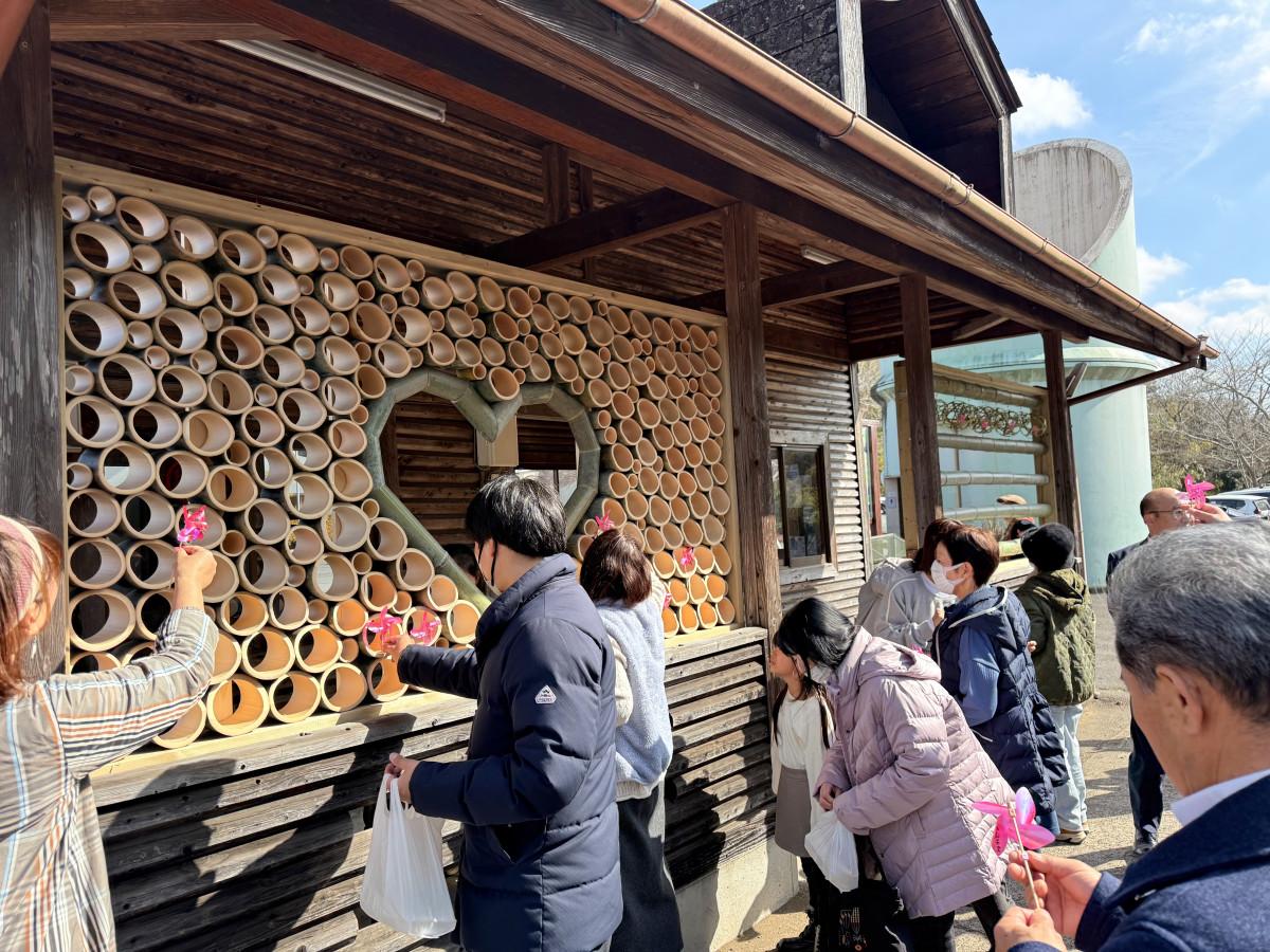 会場に設置した竹のオブジェに願いを書き込んだ風車を取り付ける参加者（写真提供＝Yellow）