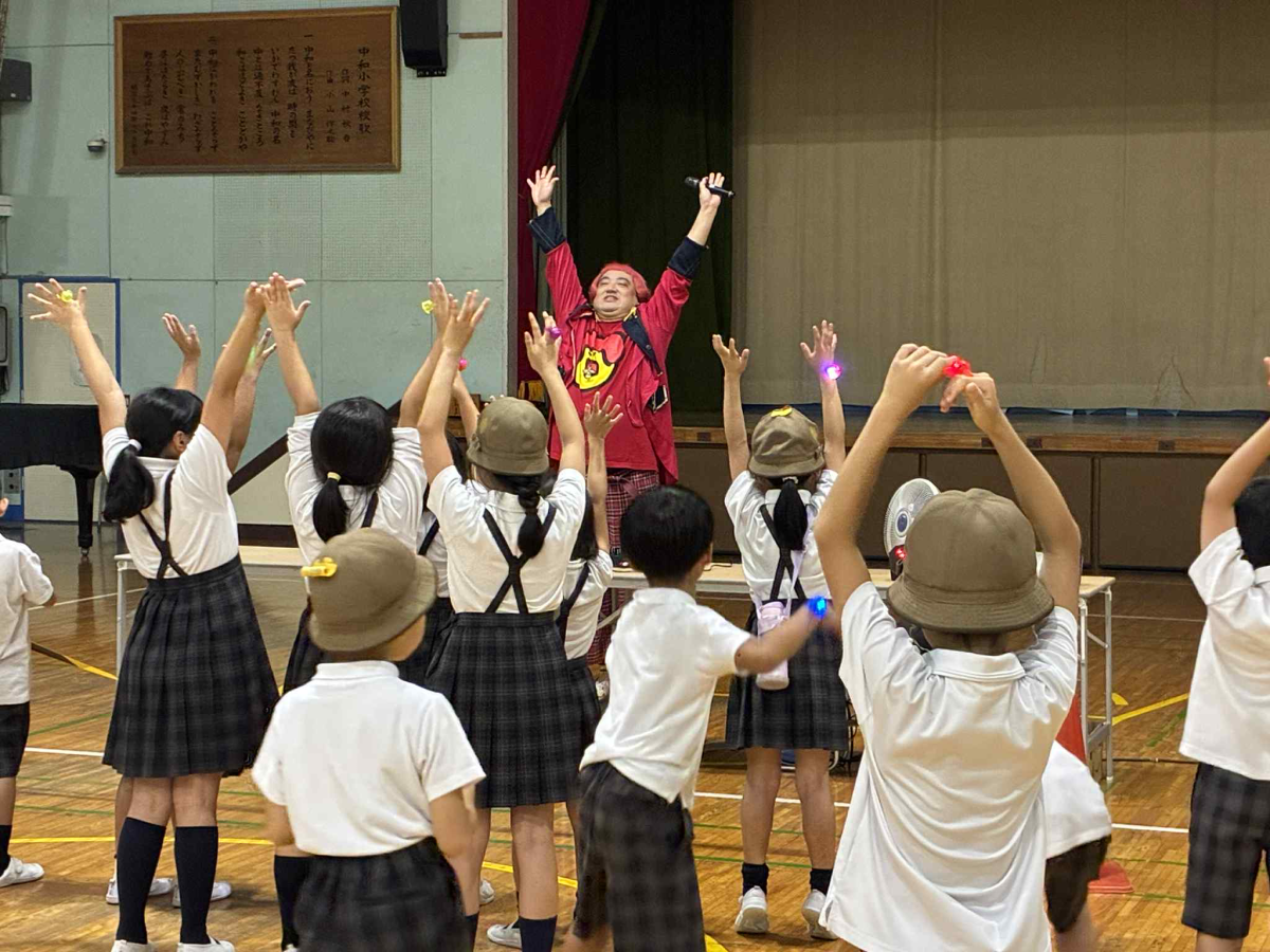 デッカチャンと一緒に音楽に合わせて体を動かす中和小学校の児童