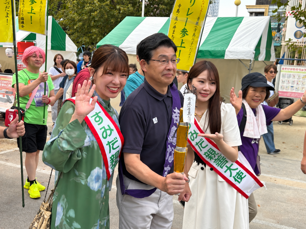 寺島なすのトーチを手にする山本亨区長と、すみだ親善大使ら