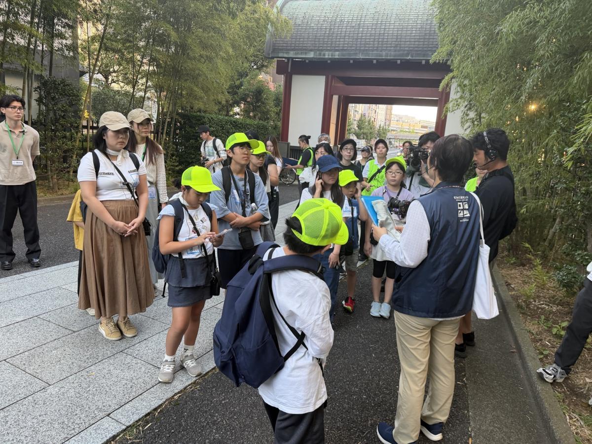 回向院でガイドの説明を聞く参加者