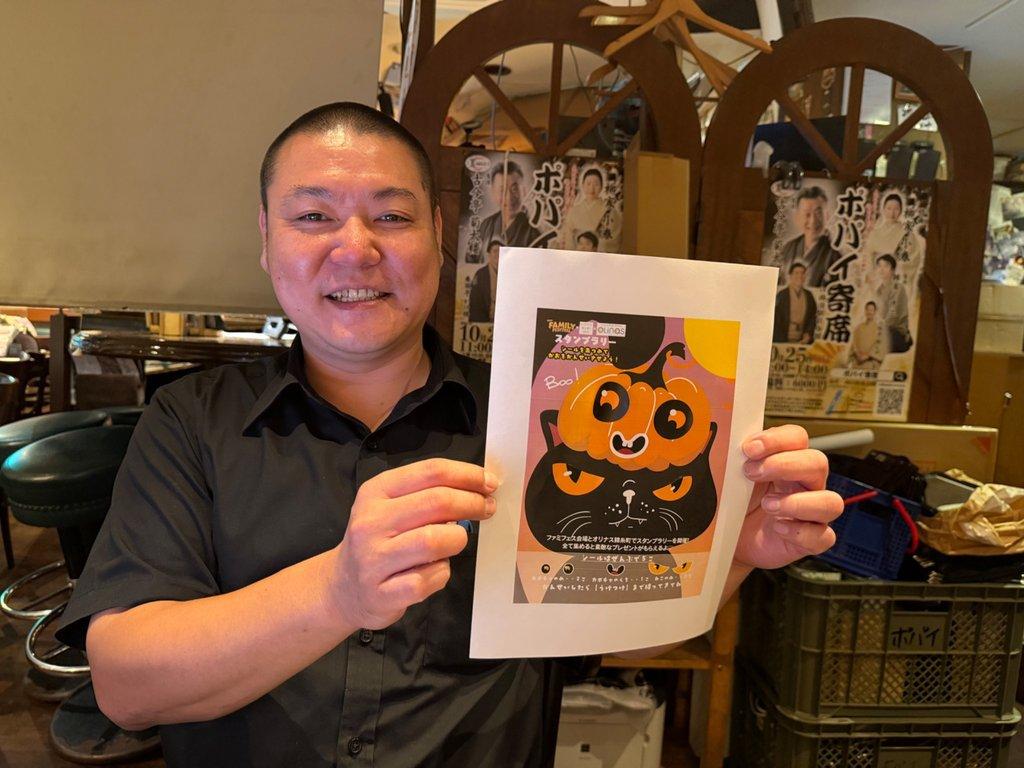 ハロウイーンスタンプラリーのイメージ図を手にする実行委員長の城戸さん