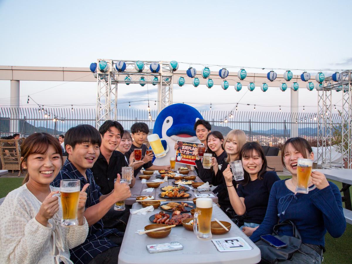ことでんのマスコットキャラクター「ことちゃん」と乾杯する来場者ら