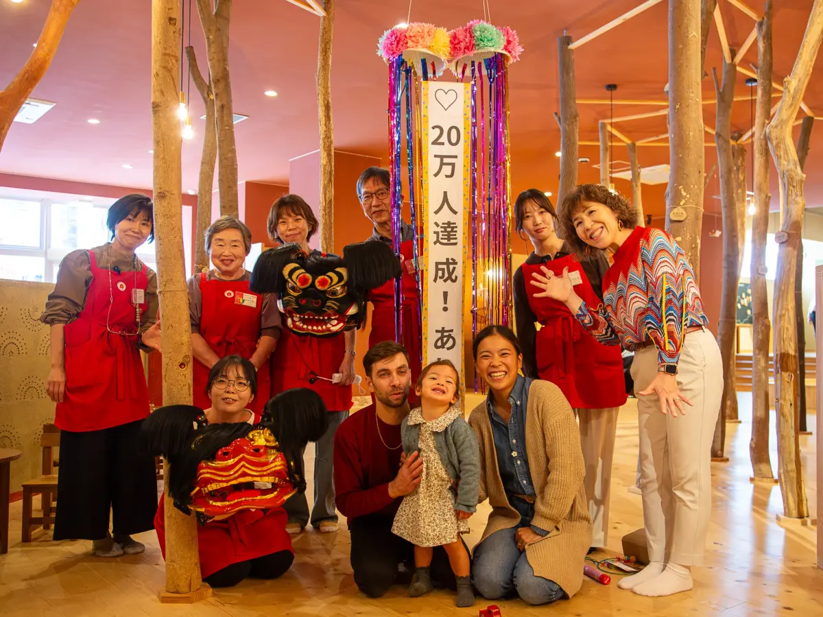 （中央前列左から）来館者20万人目になったセロニ・ニコラさん、麗成さん、未優さん。中橋恵美子館長（右端）、同館スタッフらとの記念撮影