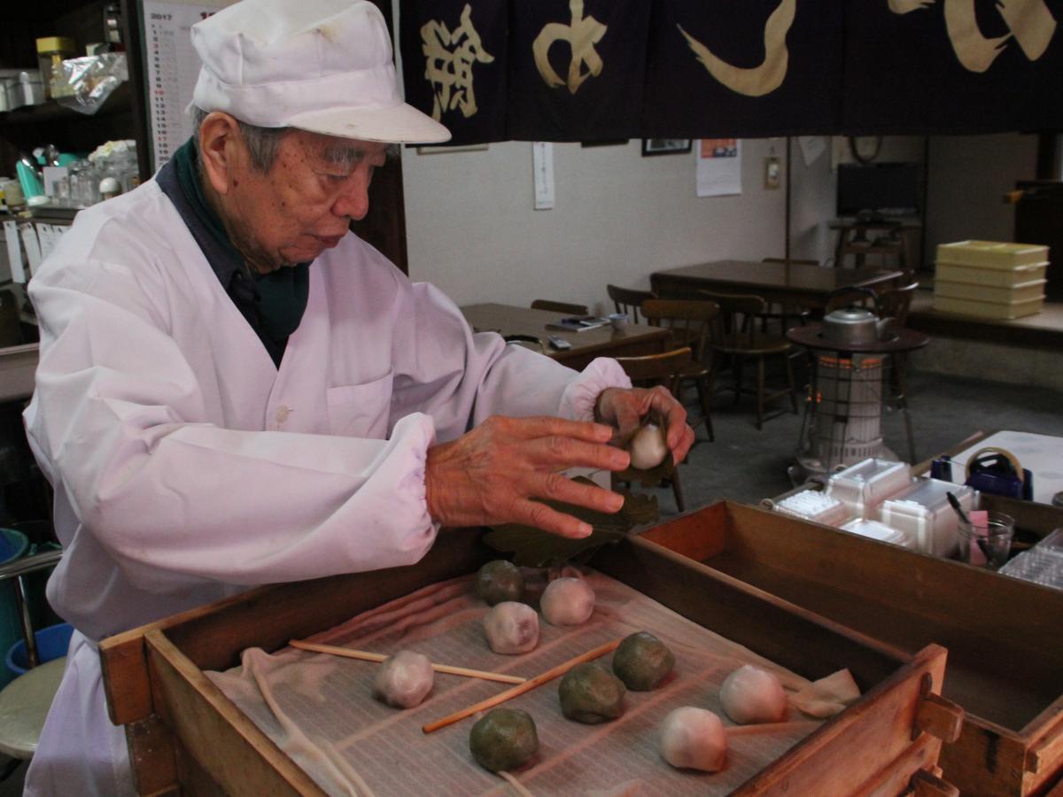 かしわ餅を包む山本さん
