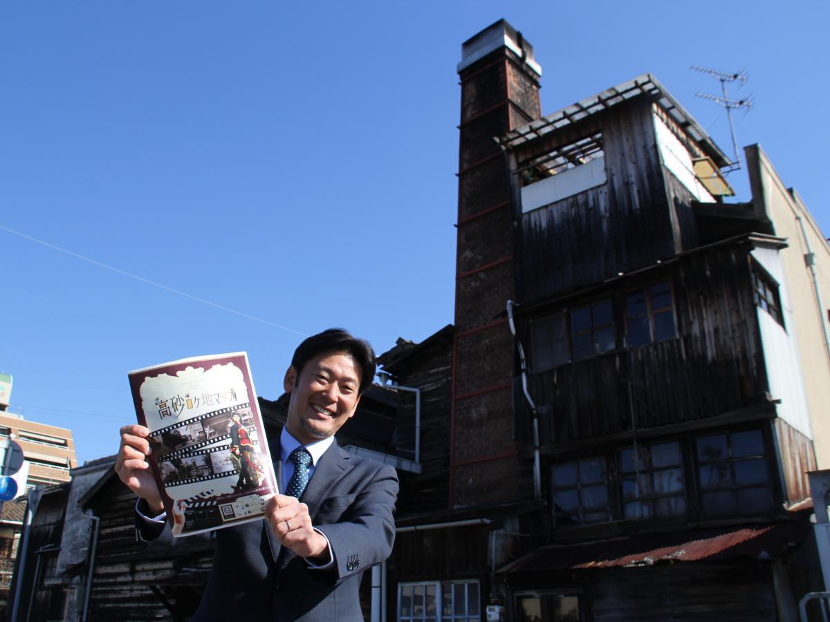 梅ヶ枝湯の前で新パンフレットをPRする藤川さん