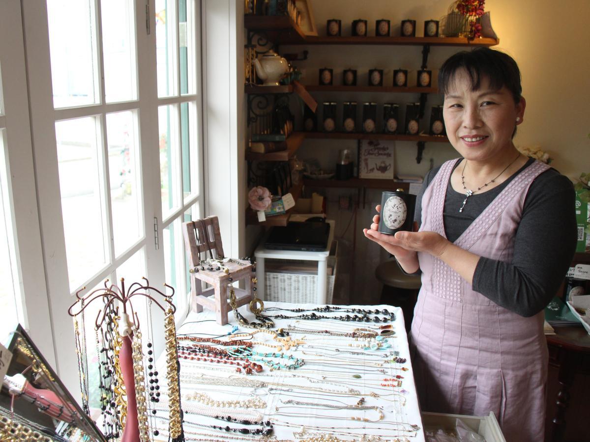 紅茶とアクセサリーを見せる店長の高橋美恵さん
