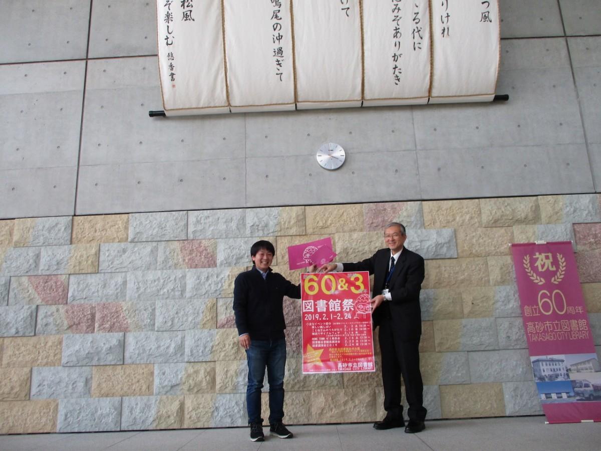 松右衛門帆と竜山石をバックに来館を呼び掛ける四方亮輔さん(左)と大塩正一さん(右)