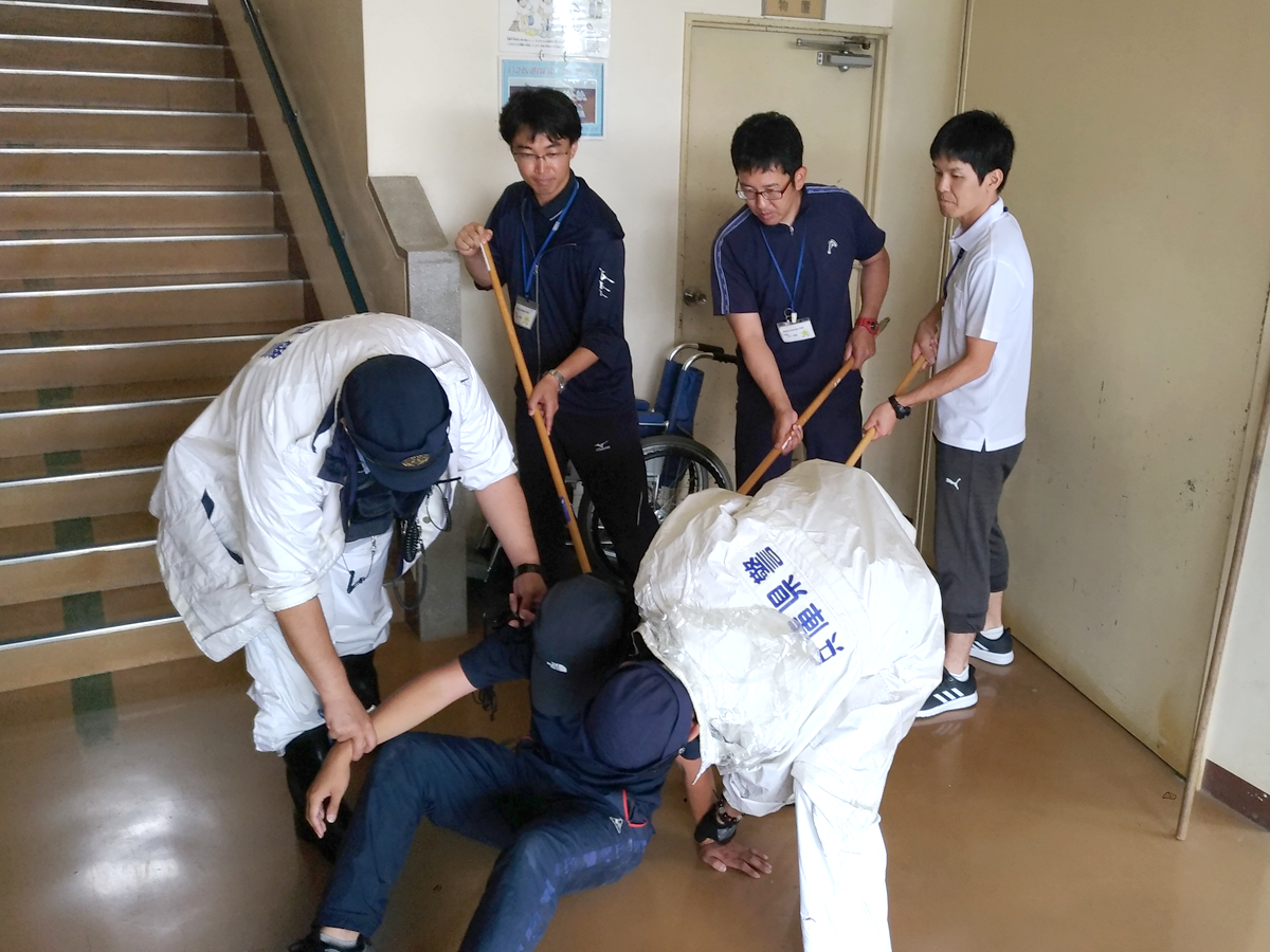 不審者役を取り押さえる警察(訓練)