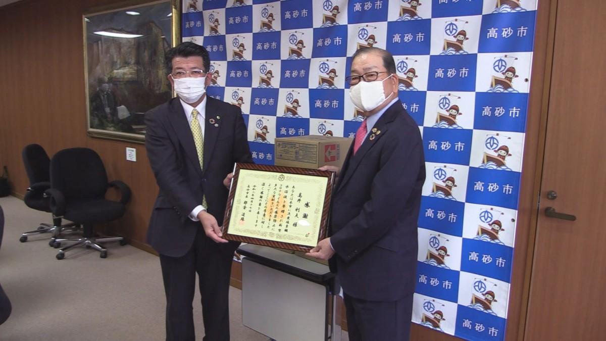 感謝状を受け取るケイ・ケイネットワークグループ会長の高井利夫さん(右)