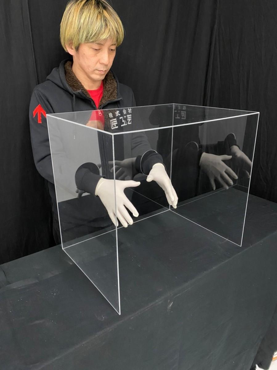 感染防止カバーのデモストレーションを行う折井さん