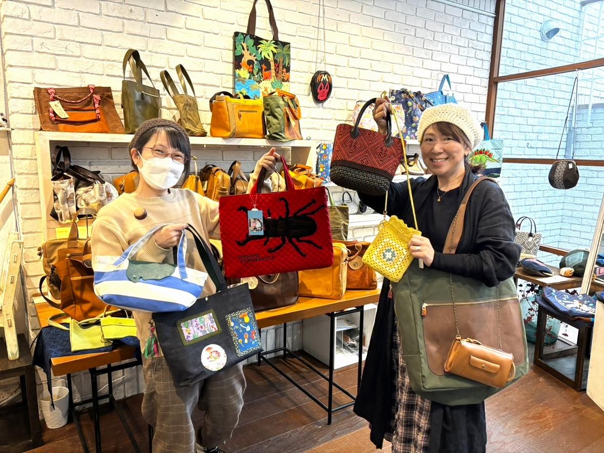 作家が手がけたかばんを持つ渡部さん（左）、池田さん（右）