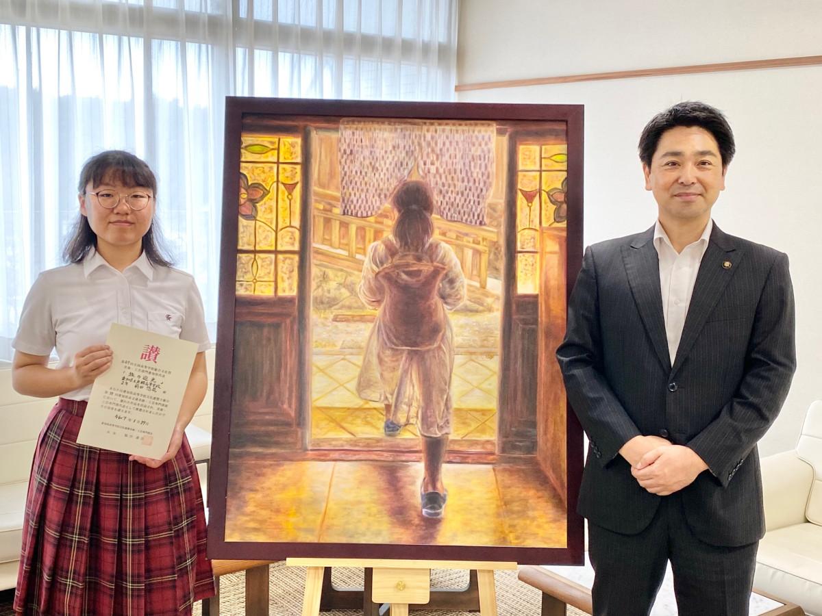 出品作品とともに小山市長(右)と記念撮影をした前田さん(左)