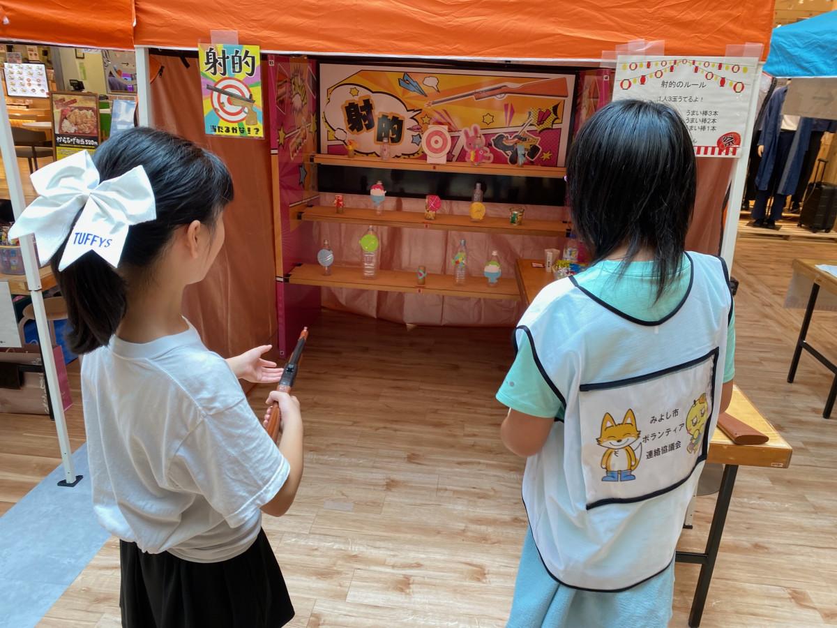 縁日ゲームでお手伝いをする参加者(右)と遊びに来た参加者(左)