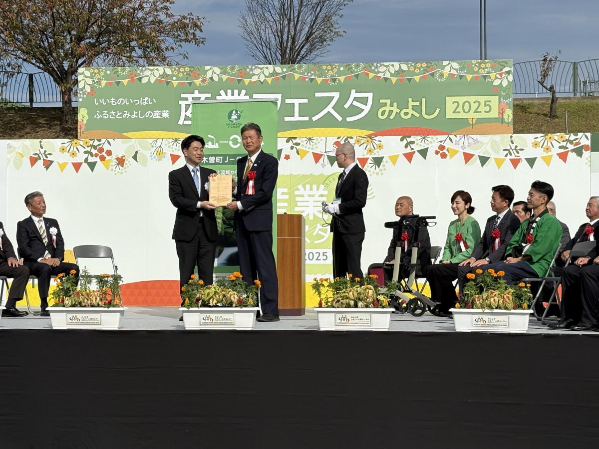 「J－クレジット認証書」を手にする小山祐・みよし市長（写真・左）と原久仁男・木曽町長（写真・右）。緑と花のセンター「さんさんの郷」にて。