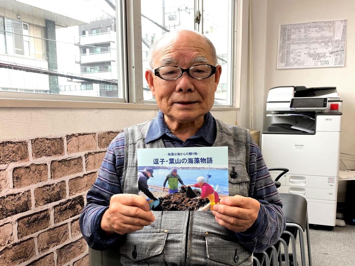 冊子「逗子・葉山の海藻物語」を手にする逗子在住の高橋昭善さん