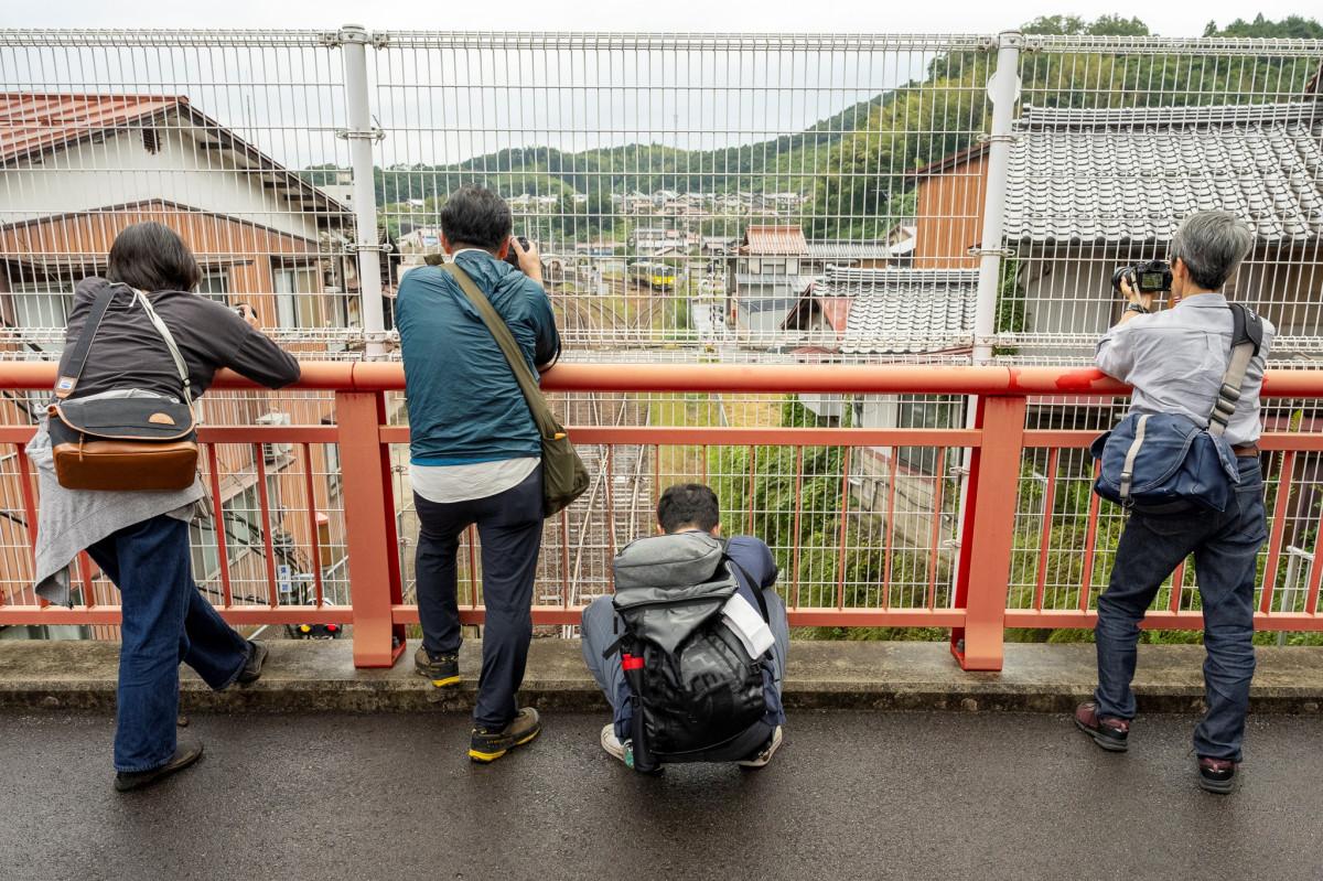 木次えびす橋の上から木次線一両列車を狙う参加者たち