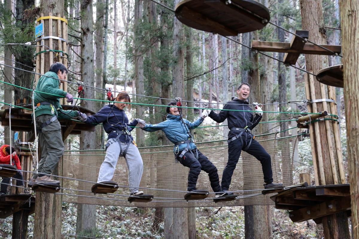 「フォレストアドベンチャー・たたらの里」で企業研修プログラムを体感する参加者たち