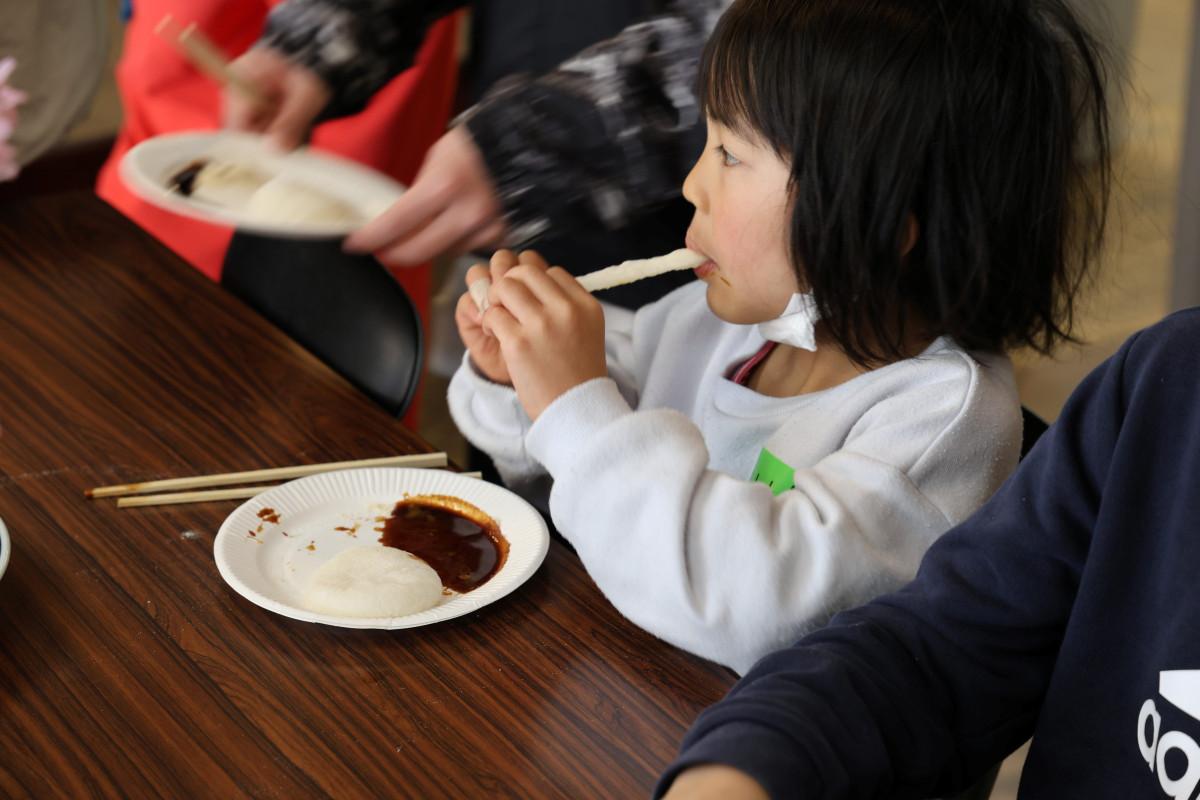 つきたての餅を食べる女児