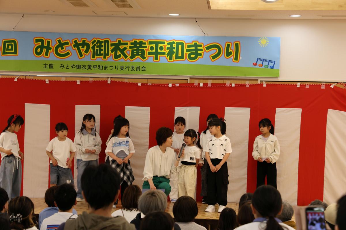 みとやスポーツクラブキッズダンスが踊りを披露後、総合司会の多久和さんからインタビューを受ける子どもたち