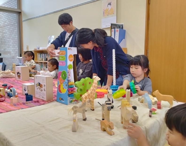 木のおもちゃを試す親子