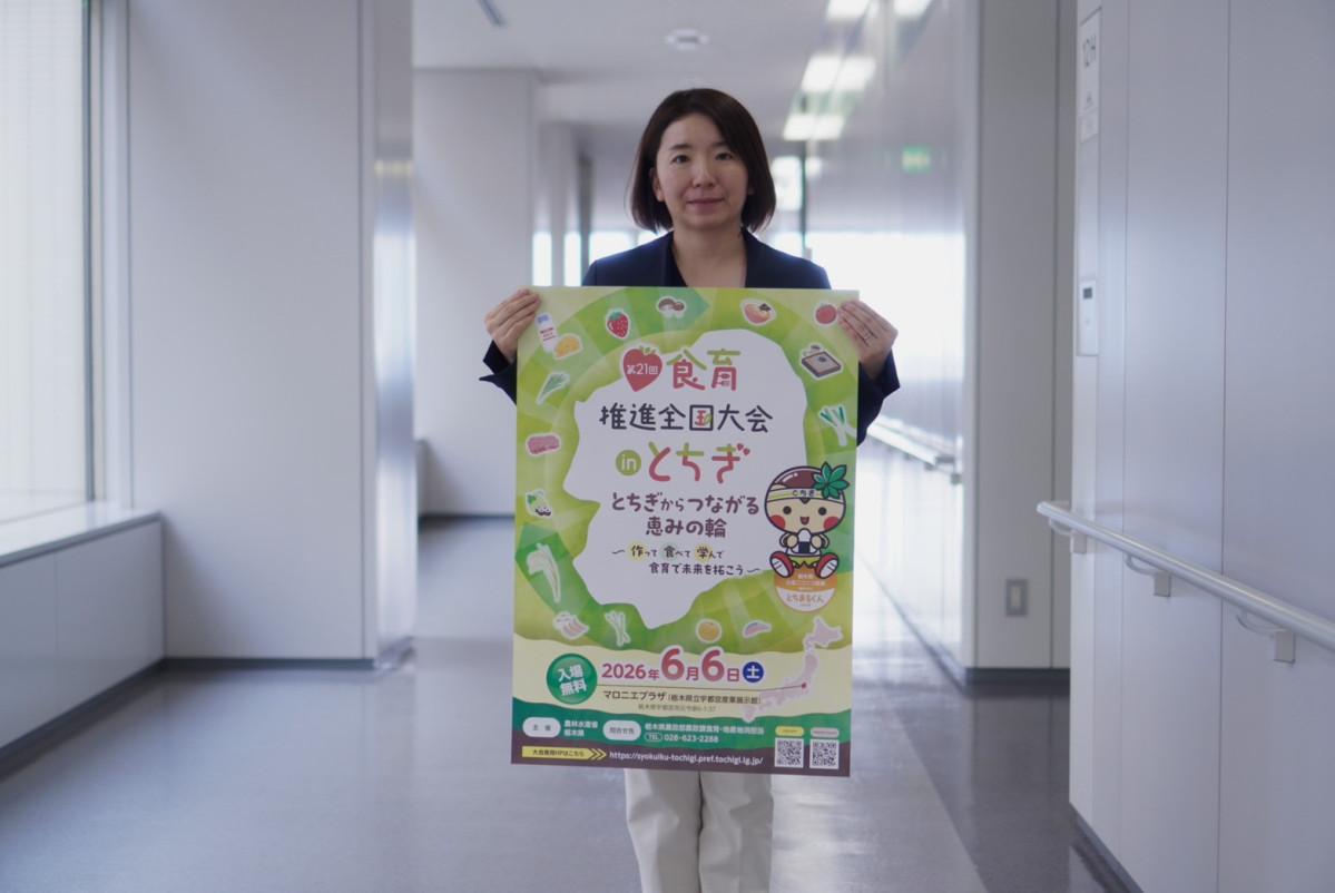 「食育推進全国大会inとちぎ」のポスターを手にする栃木県農政課の新井麻衣子さん