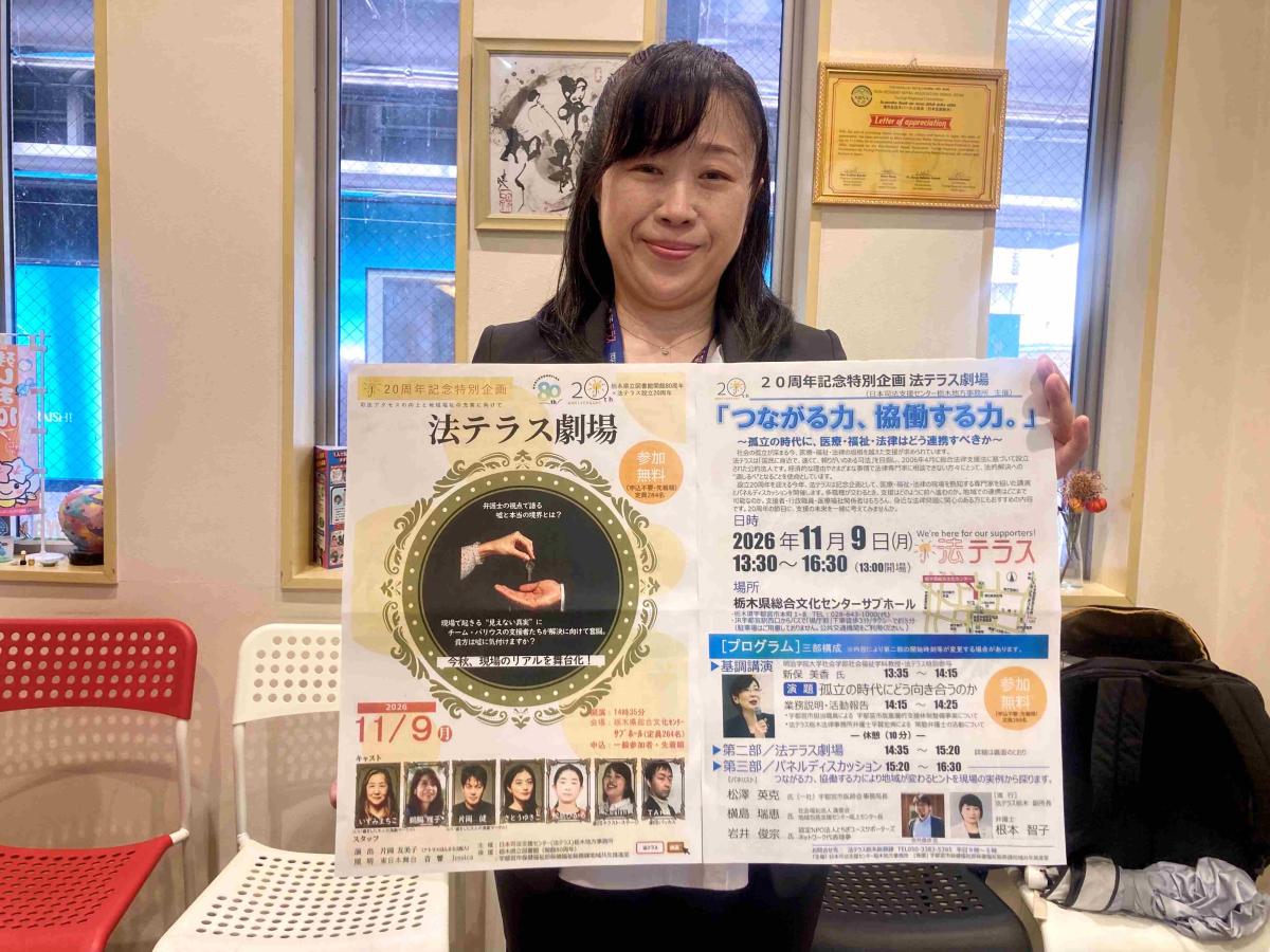 「法テラス劇場」のポスターを持つ浅井知子さん